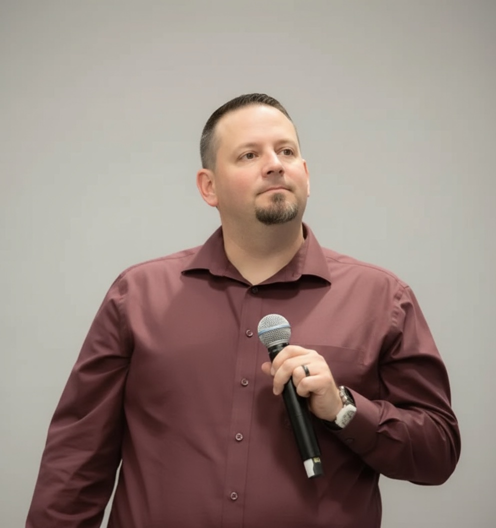 Ed Buchanan speaking, holding a microphone
